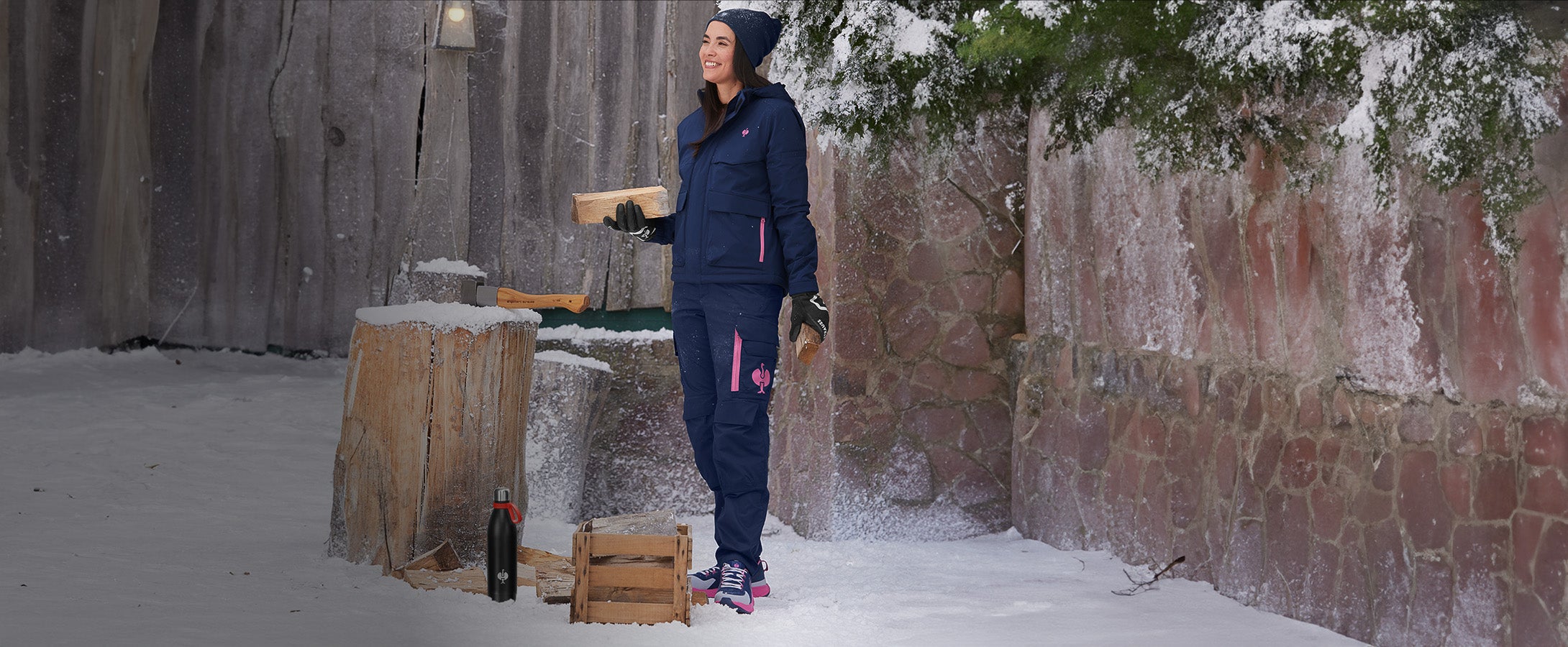 Vrouw draagt kleding uit de e.s.trail-collectie in winterse omgeving, voor haar staat een thermosfles