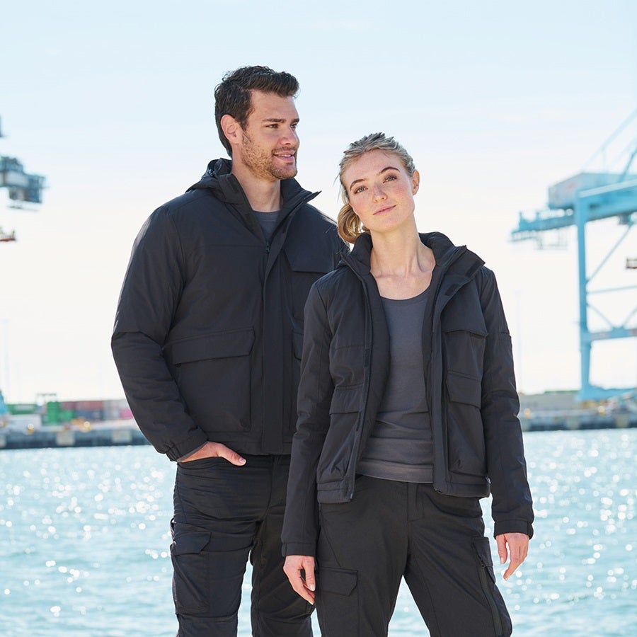 La femme et l’homme portent une veste d’hiver e.s.trail pure en gris carbone / gris basalte
