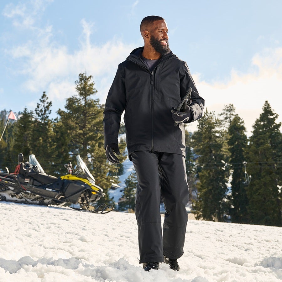 L’homme porte une veste de fonction 3 en 1 et un pantalon de fonction e.s.trail snow en noir
